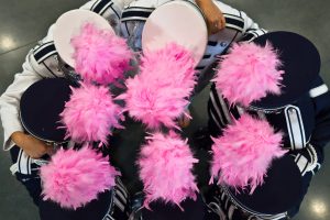 Members of the Roosevelt High School marching band model pink plumes in support of Breast Cancer Awareness month.