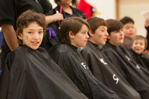 Brody students wait their turn for a head shave and a donation of their hair to Locks of Love.