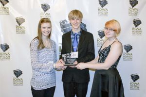 Davis Evans (middle) pauses on the red carpet with his Award of Excellence at the Iowa Motion Picture Awards.  Kara Richards (left) and Rachel Augustine (right) were cast members in the film entitled “Them.”