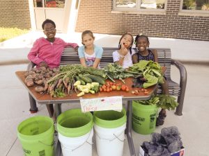 Carver Elementary students enjoy some well-earned rest and a snack after harvesting produce from their school garden.