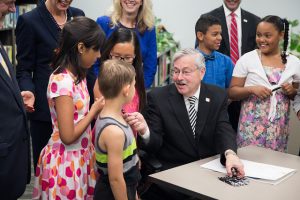 Governor Branstad distributes pens to students after signing new college savings legislative at Findley Elementary School.