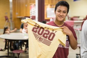 Student holds a Lincoln high school tee shirt.