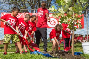 Harrison Barnes and students plant trees.