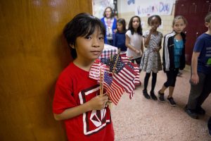 Boy holding American flags.
