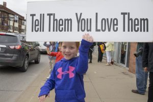 Girls holds sign that read tell them you love them