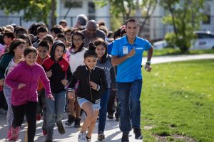U.S. Olympian Leo Manzano running with students.