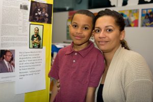 mother and son pose by a Black History Month display