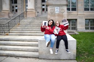 two student-journalists sitting in front of East High School