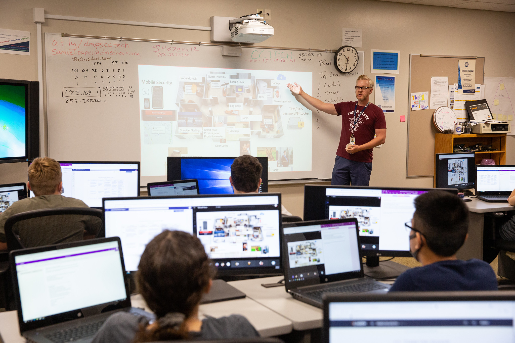 teacher instructs classroom of students using computers