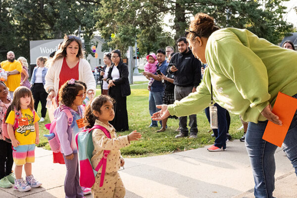 preschool students walking into their building 